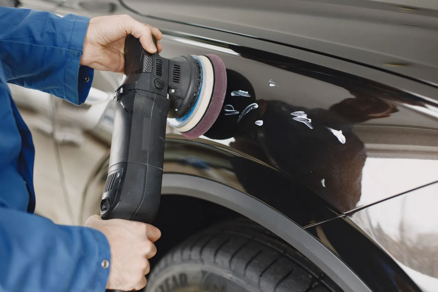 A vehicle panel being polished with a machine
