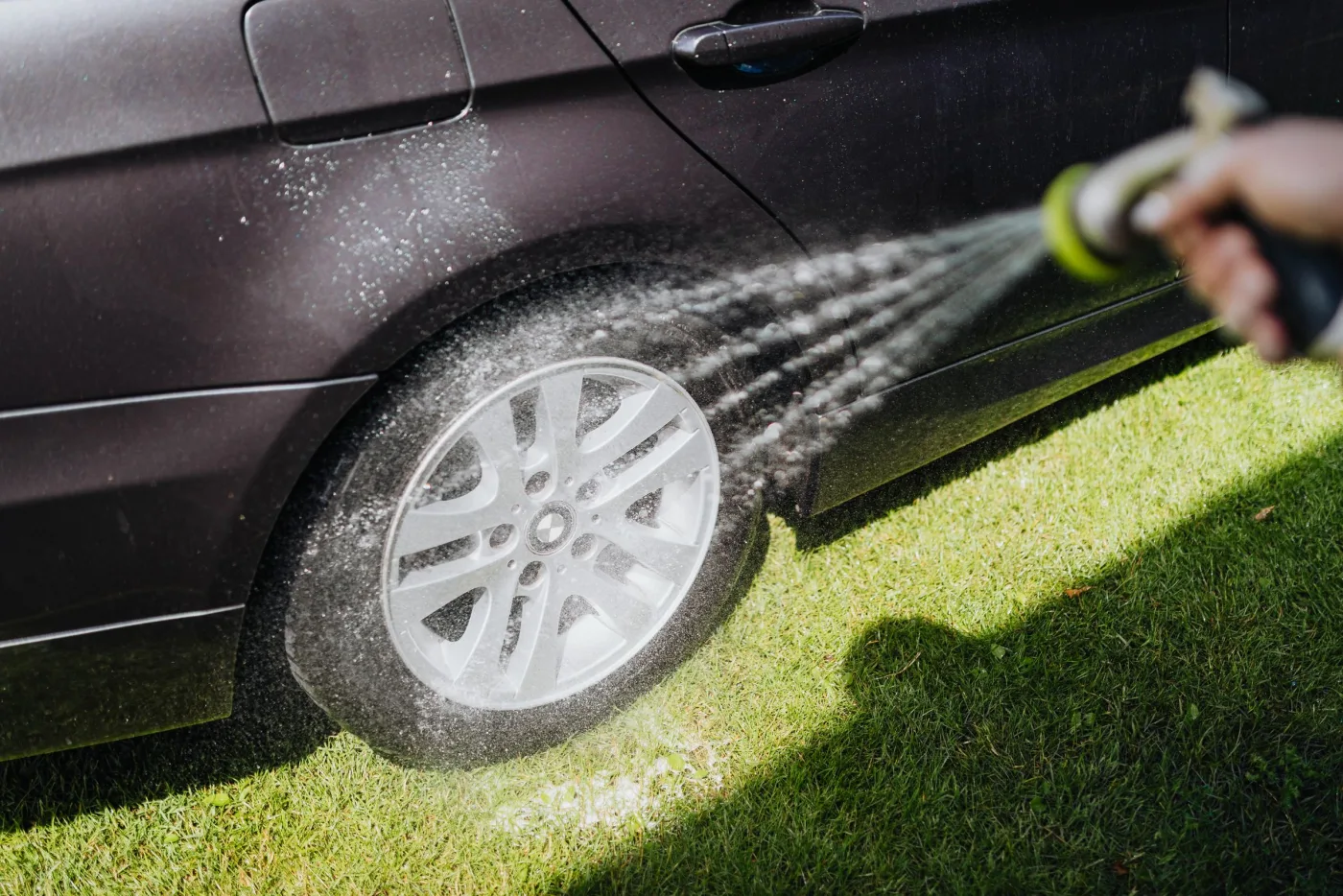 A vehicle wheel and body being rinsed with water